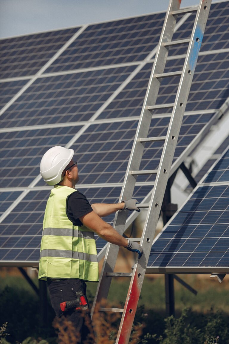 Worker in white helmet inspecting solar panels